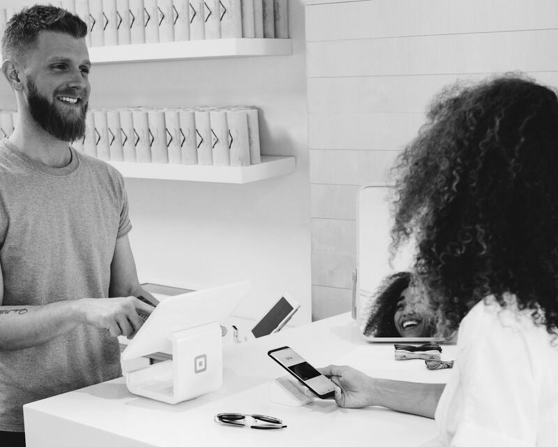 Smiling Spark Consulting brand representative talking face to face with a customer at a store counter